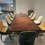 High-Gloss Amber Burl Wood Dining Table with Cream Quilted Leather Base and Metal Inlay